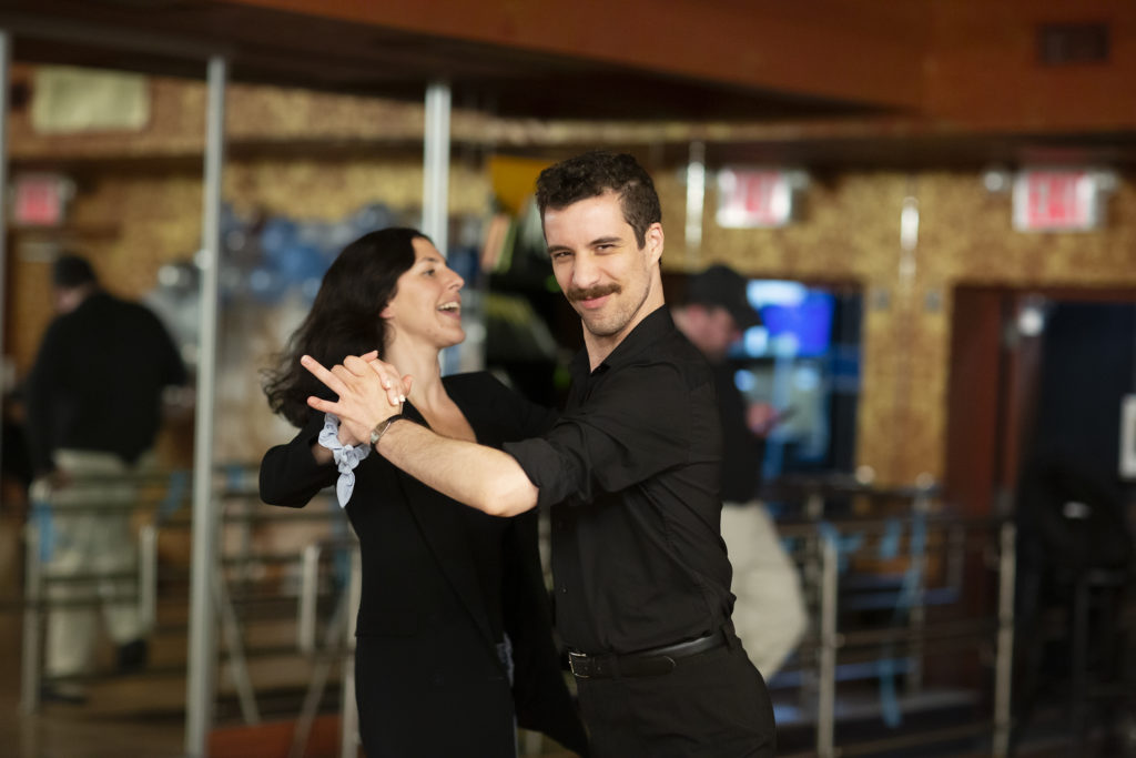Teacher and dance student are in hold, dancing bachata