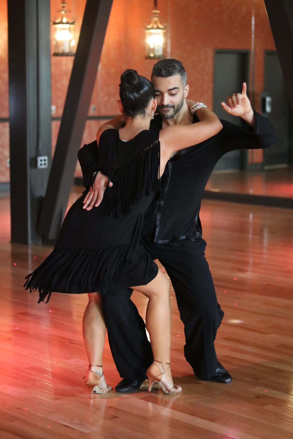 Instructor and partner in a close bachata hold on the Dance With Me Austin studio floor