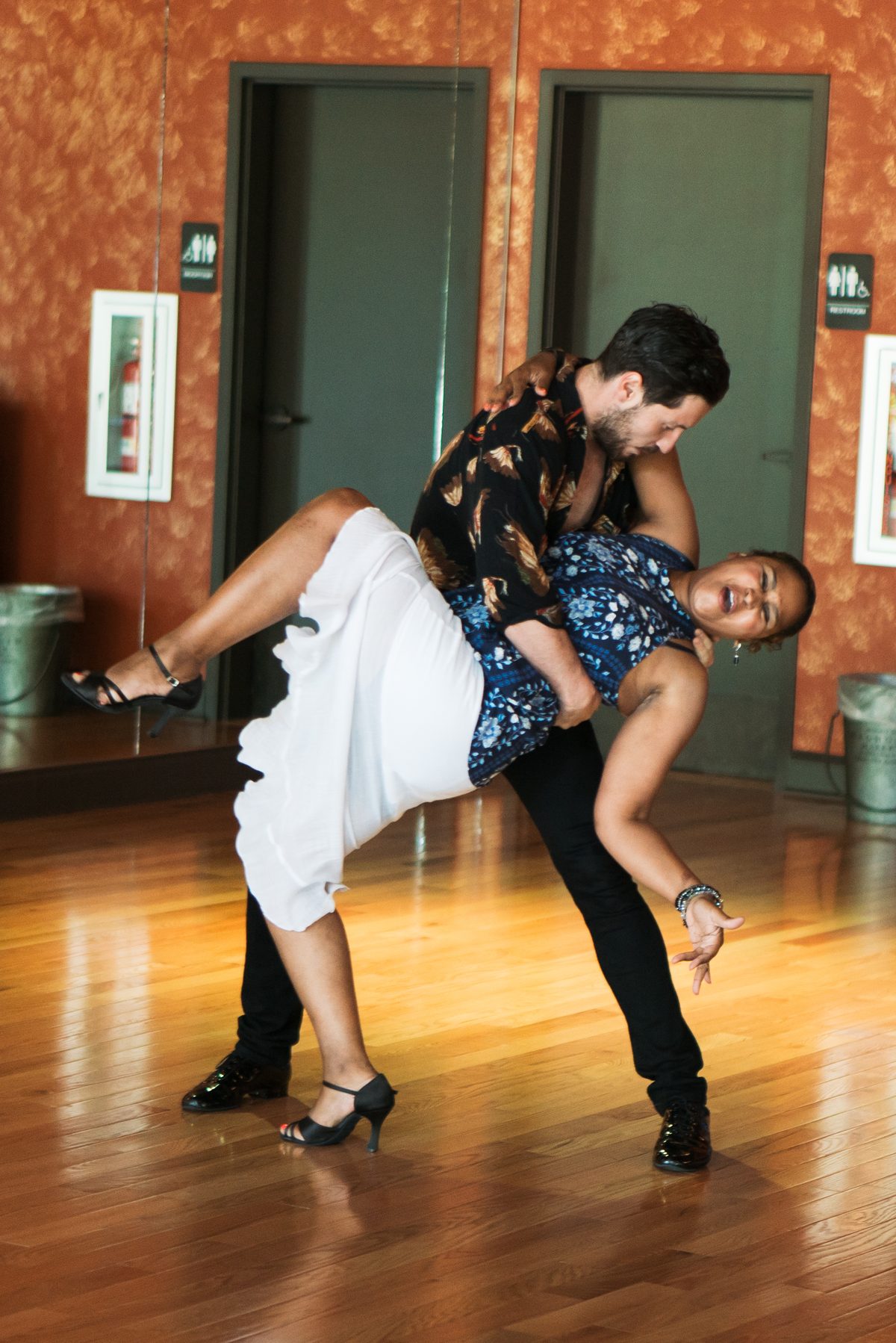Instructor guiding a student through a bachata dip in a private lesson