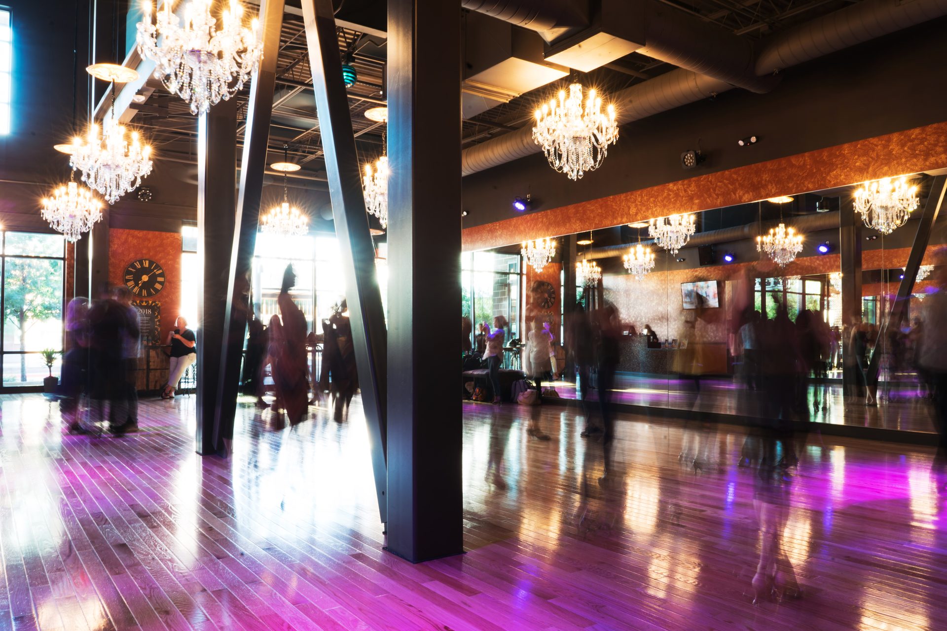 Chandeliers and the wood dance floor inside Dance With Me Austin at Domain NORTHSIDE