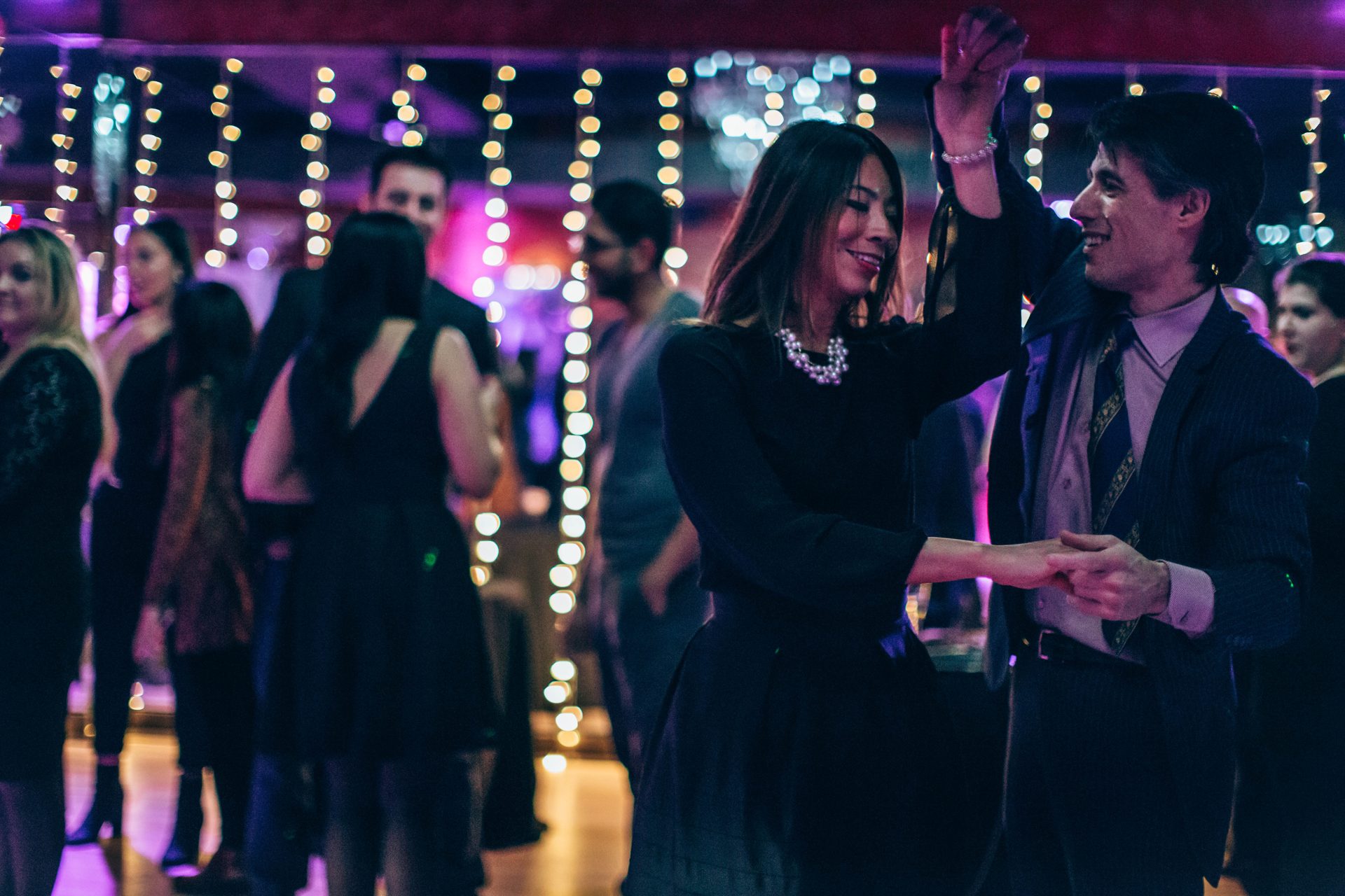 Couple smiling while social dancing salsa at a studio practice party