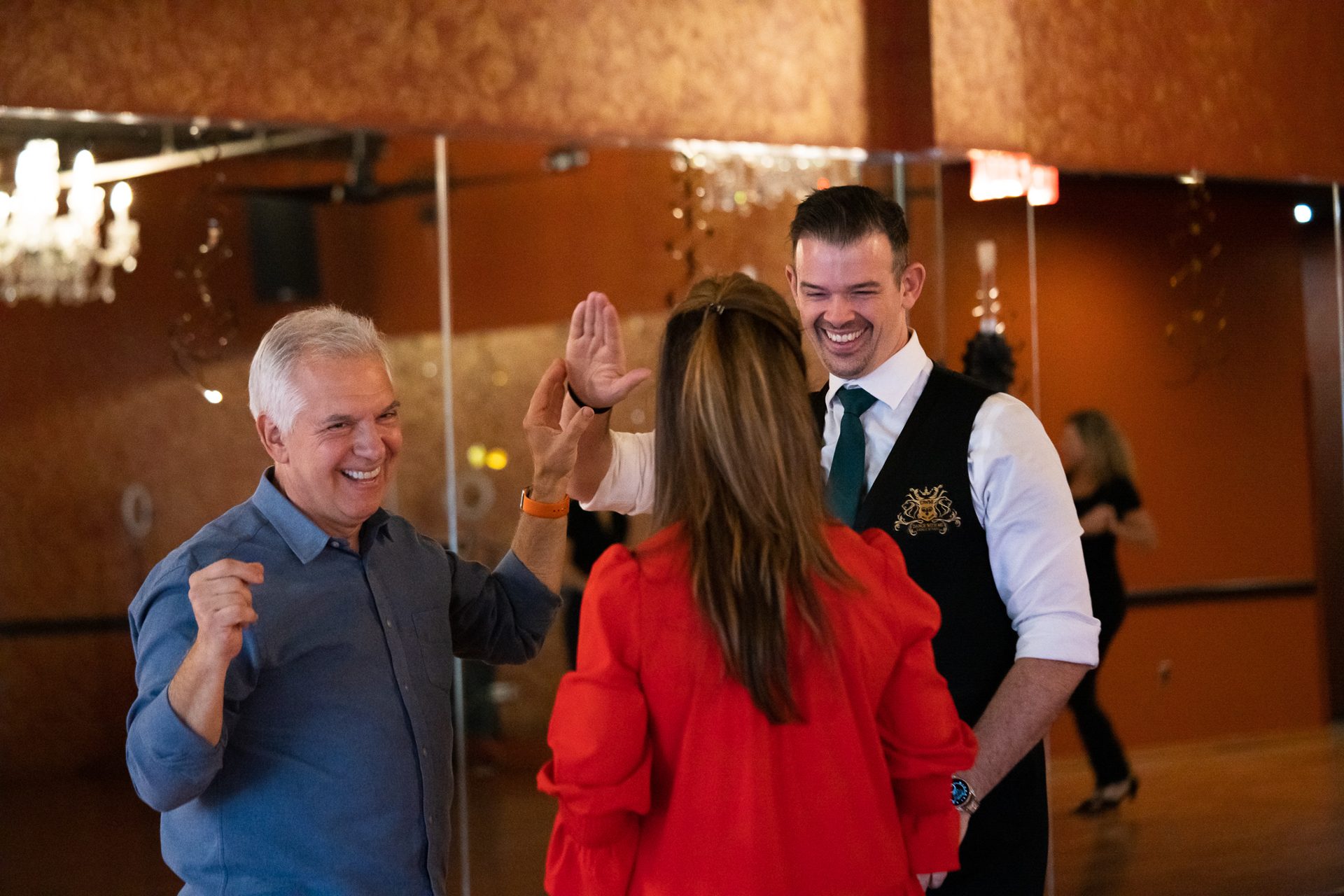 Instructor coaching a smiling adult student during a private salsa lesson
