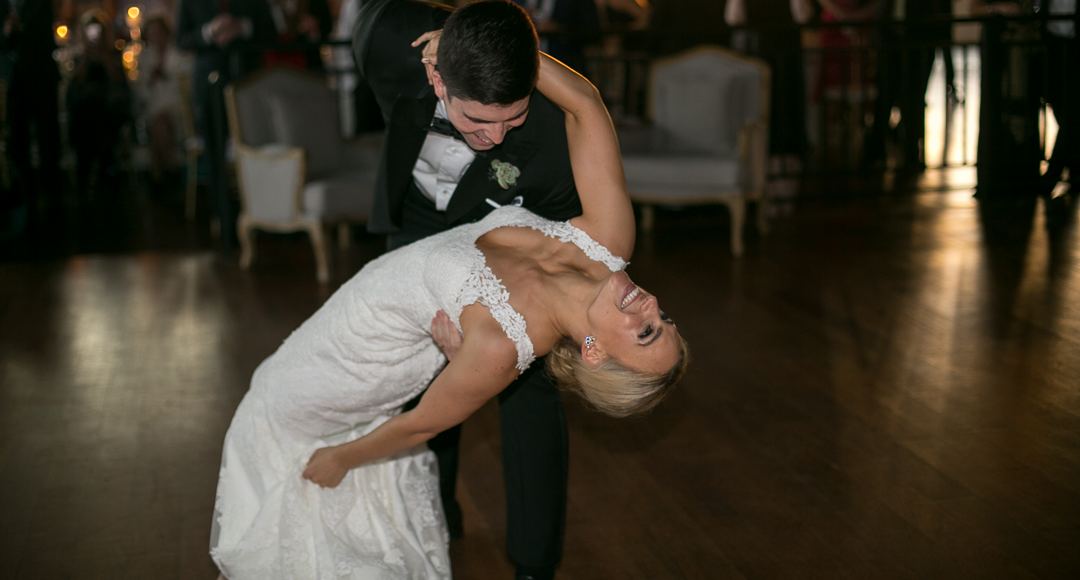 Couple laughing through a dip during their wedding first dance
