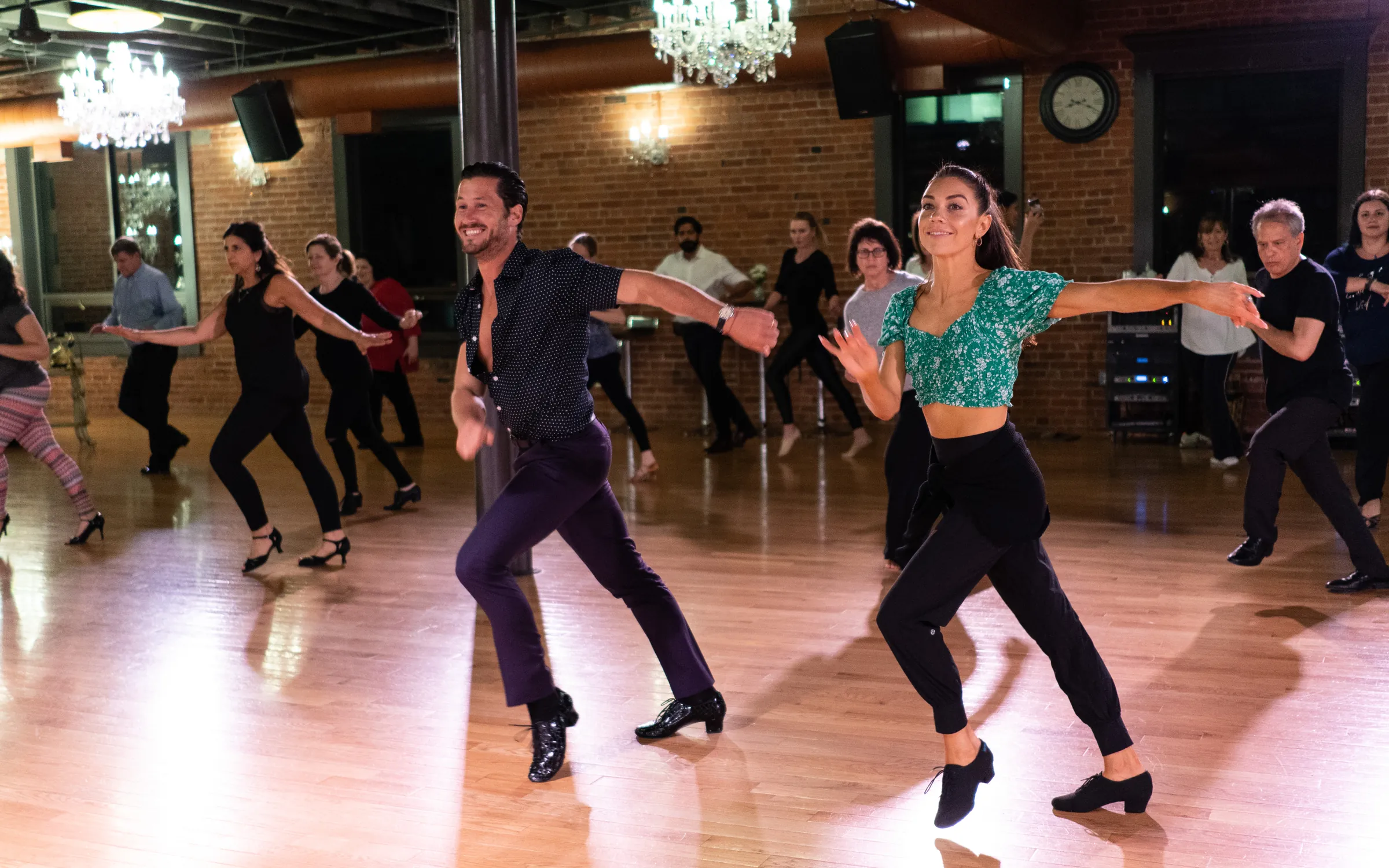 Adults of all ages following a group dance class on the ballroom floor at Dance With Me Stamford