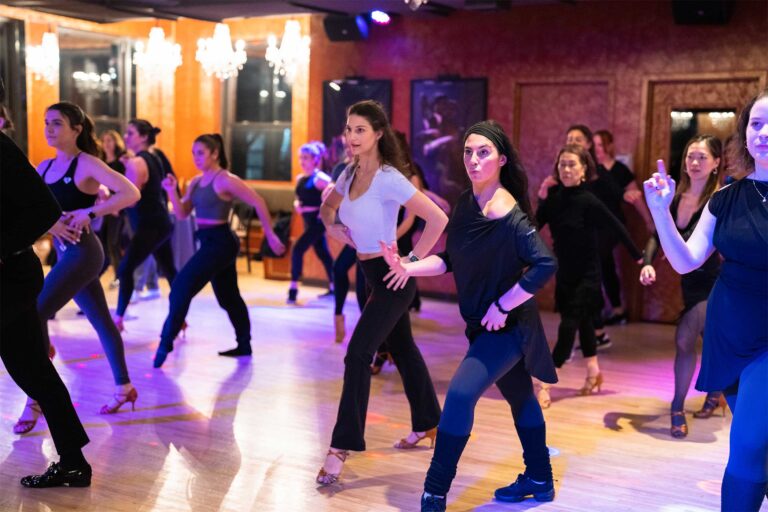 Students dancing the Electric Slide in a line at a Dance With Me group class